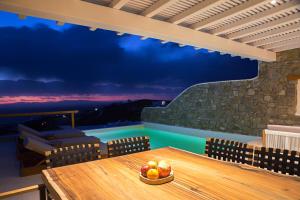 a table with a bowl of fruit on a balcony at VILLA ATHENA- Private Pool- Amazing Aegean View in Fanari