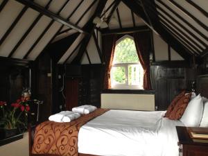 a bedroom with a large bed with a window at Lyons Woodlands Hall in Ruthin