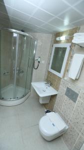 a bathroom with a shower and a toilet and a sink at Olbia Hotel in Antalya