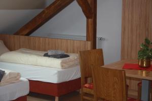 a small bedroom with a bed and a table at Pension Mair in Stetten