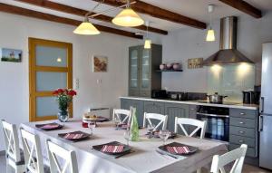 una cucina con tavolo, sedie bianche e una sala da pranzo di Gîte de Languivoa a Plonéour-Lanvern