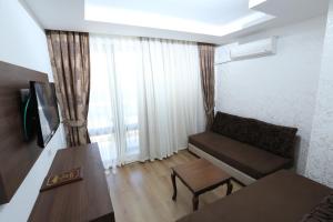 a living room with a couch and a table at Olbia Hotel in Antalya