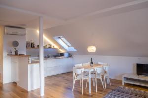 a kitchen and dining room with a table and chairs at HOMe apartments & Yoga studio in Bled-Rečica
