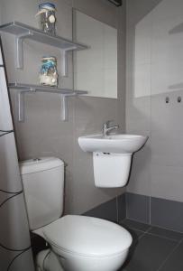 La salle de bains est pourvue de toilettes et d'un lavabo. dans l'établissement Domki Nemo, à Gąski