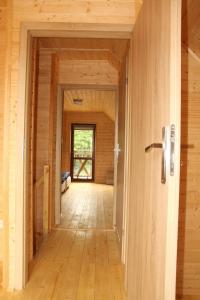 - un couloir dans une maison en bois avec une porte dans l'établissement Domki Nemo, à Gąski