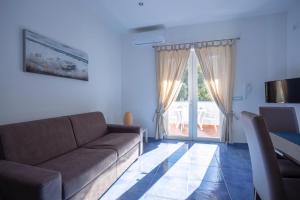 uma sala de estar com um sofá e uma porta de vidro deslizante em Casa Restituta em Ischia