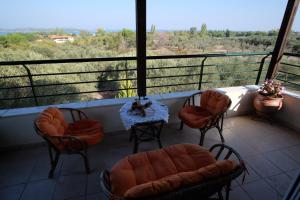 a balcony with chairs and a table with a view at Billias House in Vourvourou