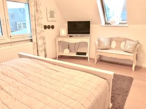 a bedroom with a bed and a tv and a chair at Ferienhaus Strandgut in Zingst