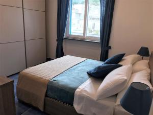 a bedroom with a bed with pillows and a window at Casa Restituta in Lacco Ameno