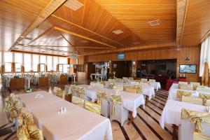 a banquet hall with white tables and yellow chairs at Olbia Hotel in Antalya