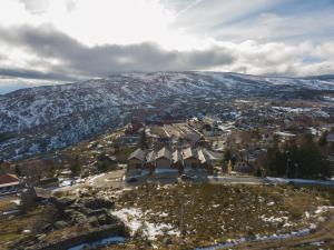 an aerial view of a town with a snow covered mountain at Estrela da Serra - Alojamento Local in Penhas da Saúde