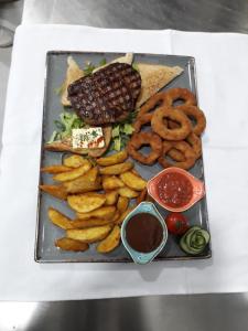 une assiette de nourriture avec des anneaux d'oignons et un hamburger dans l'établissement Hotel Rafaelo, à Bosanska Dubica