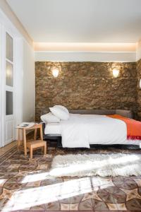 a bedroom with a bed and a stone wall at Nest in Athens