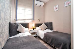 a small room with two beds and a window at tuGuest Darro Apartment in Granada