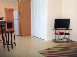 a living room with a television and a refrigerator at Beacon Rise Apartment in Basse Terre Town