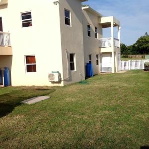 una casa blanca con un patio delante en Beacon Rise Apartment en Basseterre