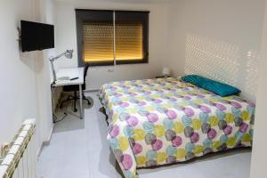 1 dormitorio con 1 cama y escritorio en una habitación en Carrer Sevilla, en Tarragona