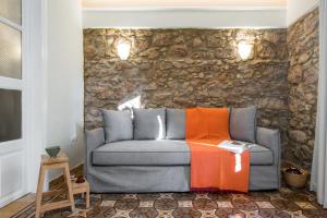 a couch in a room with a stone wall at Nest in Athens