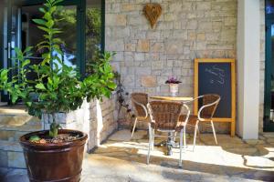 a patio with a table and chairs in front of a building at Kleine Hexe B&B Pension in Pirovac