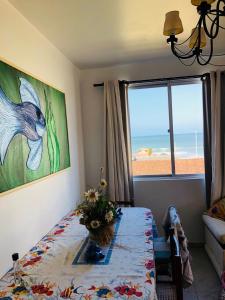 - une salle à manger avec une table et une vue sur l'océan dans l'établissement Aconchegante apartamento a beira mar barra velha, à Barra Velha