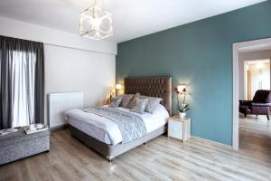 een slaapkamer met een bed en een blauwe muur bij Volos View in Volos