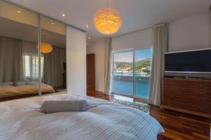 a bedroom with a large bed and a large window at Marela in Dubrovnik