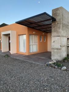 ein Gebäude in Orange und Weiß in der Unterkunft Apart Las Palmeras Corcovado in Villa Rumipal