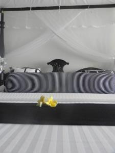 a black and white bed with a yellow flower on it at Amanda Beach Villas in Unawatuna