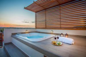 Un baño con bañera y una mesa con copas de vino. en Casa Delphine, en San Miguel de Allende