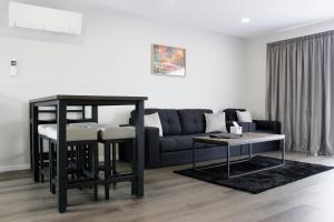 a living room with a couch and a table at Colonial Motel in Invercargill