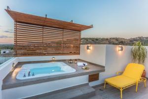 Un baño con bañera y una silla amarilla. en Casa Delphine, en San Miguel de Allende