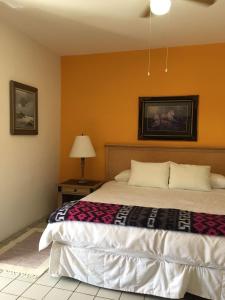 HOTEL BOUTIQUE EL VIEJO MUNDO في هيدالجو ديل بارال: غرفة نوم بسرير وطاولة مع مصباح