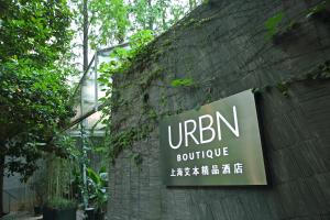 a sign on the side of a brick wall at URBN Boutique Shanghai in Shanghai