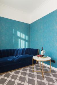 a living room with a blue couch and a table at Altay Hotel in Barnaul