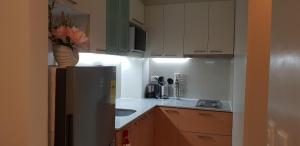 a small kitchen with a refrigerator and a sink at One Pacific Residence with Ocean View in Mactan
