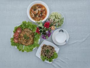 a table with a plate of food and a bowl of soup at Chanhthida Riverside Guesthouse and The River Front Restaurant in Ban Khon