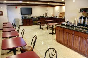a restaurant with tables and chairs and a bar at Ramada by Wyndham Grand Junction in Grand Junction
