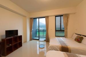 a hotel room with two beds and a large window at 七號會館 in Puli +68 photos