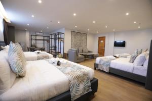 Habitación de hotel con 3 camas y sala de estar. en Balar Hotel and Spa en Boac
