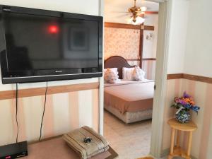 1 dormitorio y sala de estar con TV de pantalla plana. en Genting Sempah Berjaya Hill Cottage, en Bukit Tinggi