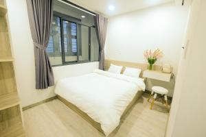 Postel nebo postele na pokoji v ubytování Dlux Saigon