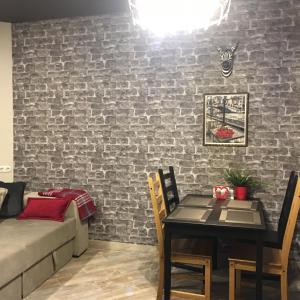 a living room with a table and a brick wall at Apartment Zebra in Estosadok