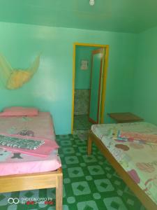 a room with two beds and a mirror at Valine Grace Cottages in El Nido