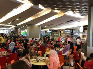 a group of people sitting at tables in a restaurant at KLCC Apartment in Kuala Lumpur