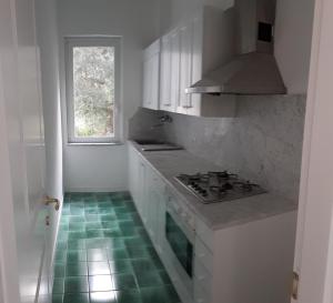 - une cuisine avec des placards blancs et du carrelage vert dans l'établissement CASA LONE, à Amalfi