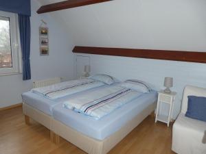 a bedroom with a large white bed and a chair at Huis Pimpernel in Bredene