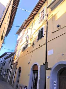 a yellow building with arched windows on a street at calloni franceschini home in Palaia