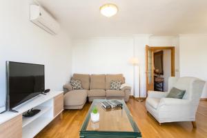 sala de estar con sofá y TV en Villamar - Relax, Sol y Playa, en Alicante