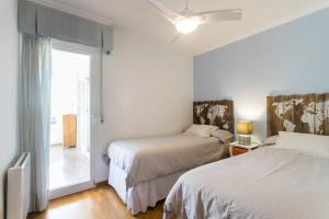 アリカンテにあるVillamar - Relax, Sol y Playaの白い部屋で、ベッド2台、窓が備わります。