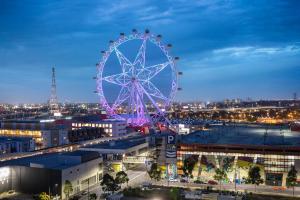 a large ferris wheel in a city at night at Quest NewQuay in Melbourne